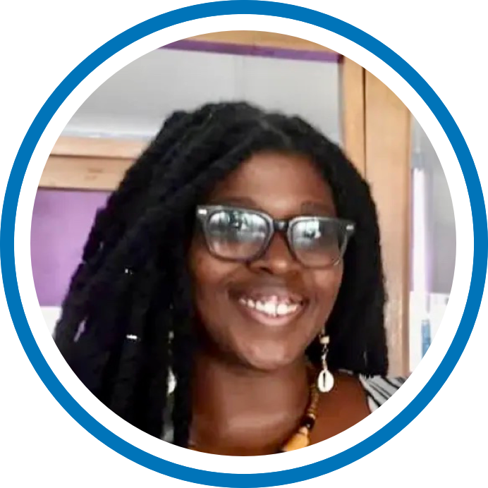 Headshot of Omosede Eholor a woman with long black hair and eyeglasses wearing a colorful blouse